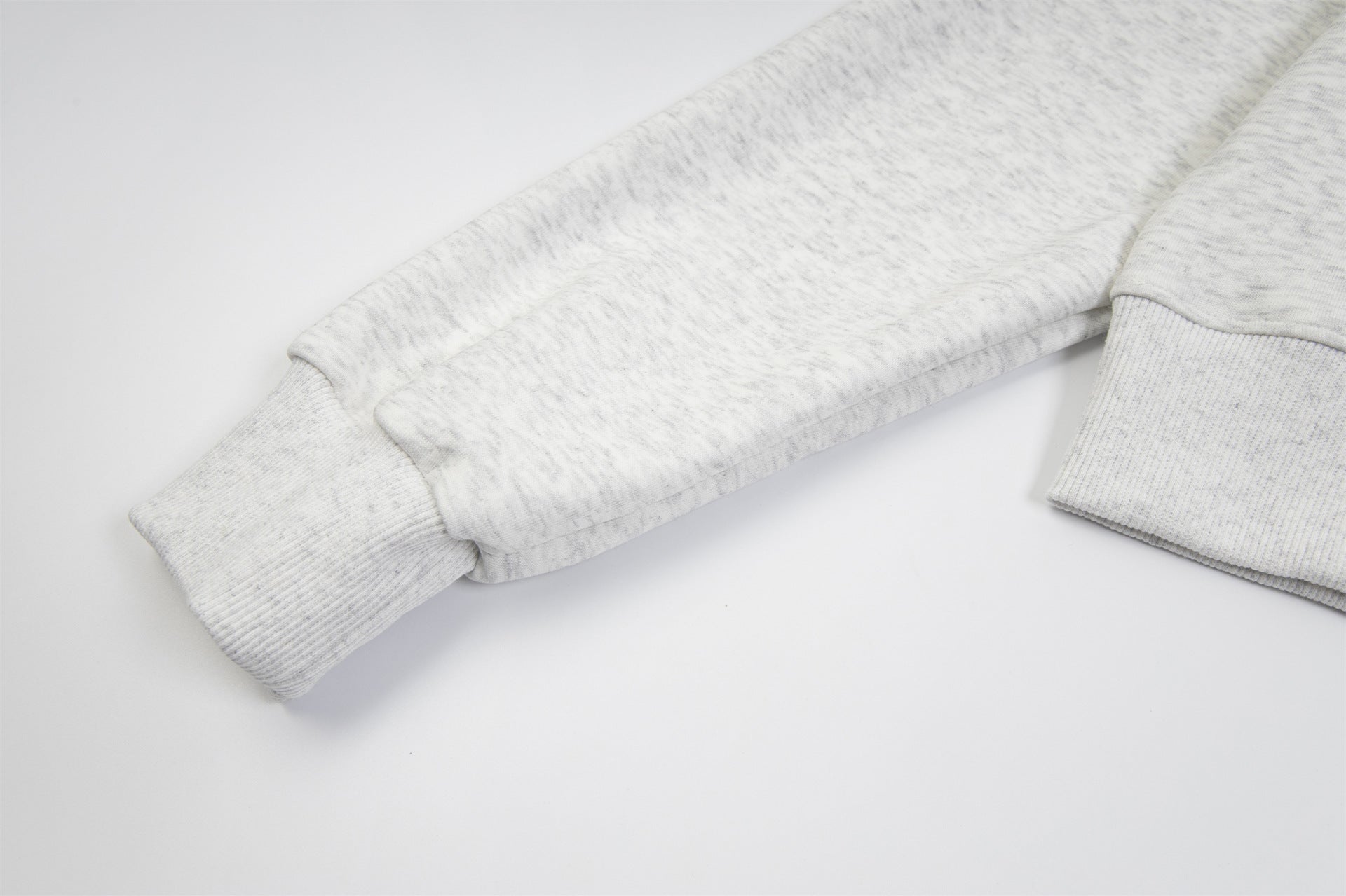 Close-up of the cuff of a grey fleece hoodie showcasing soft fabric and comfortable fit.