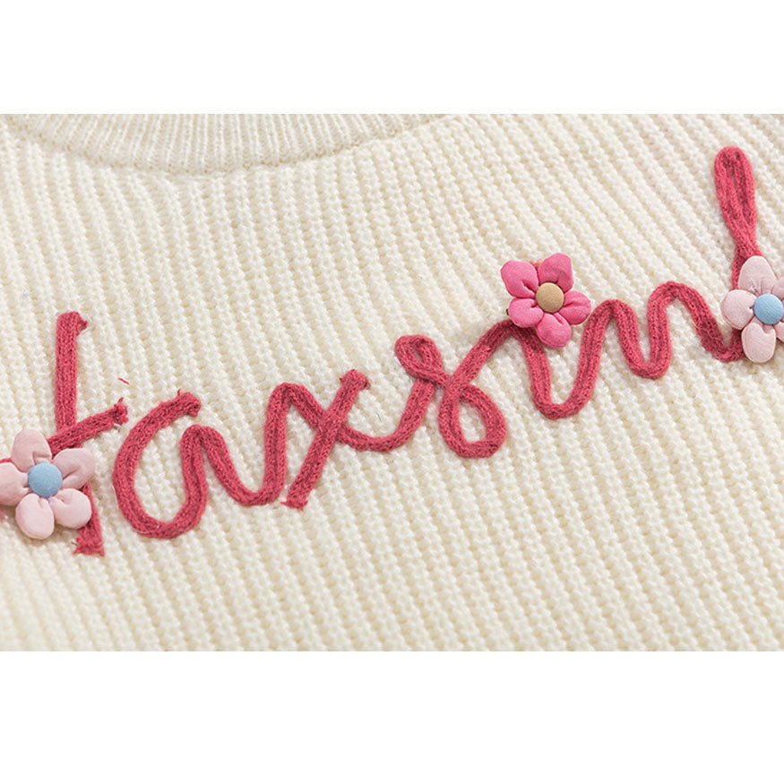 Suéter recortado con patrón de flores y letras